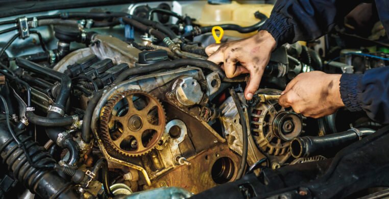 Car mechanic repairing an engine. Mechanic working on car engine. Mechanic workshop.